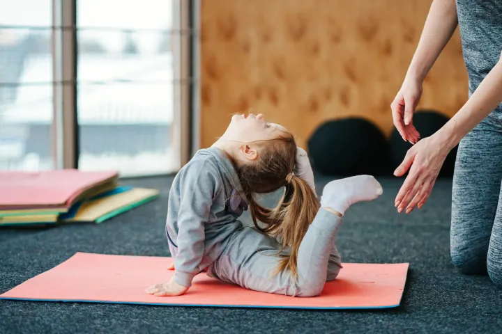 Mädchen übt eine Yogahaltung auf der Matte