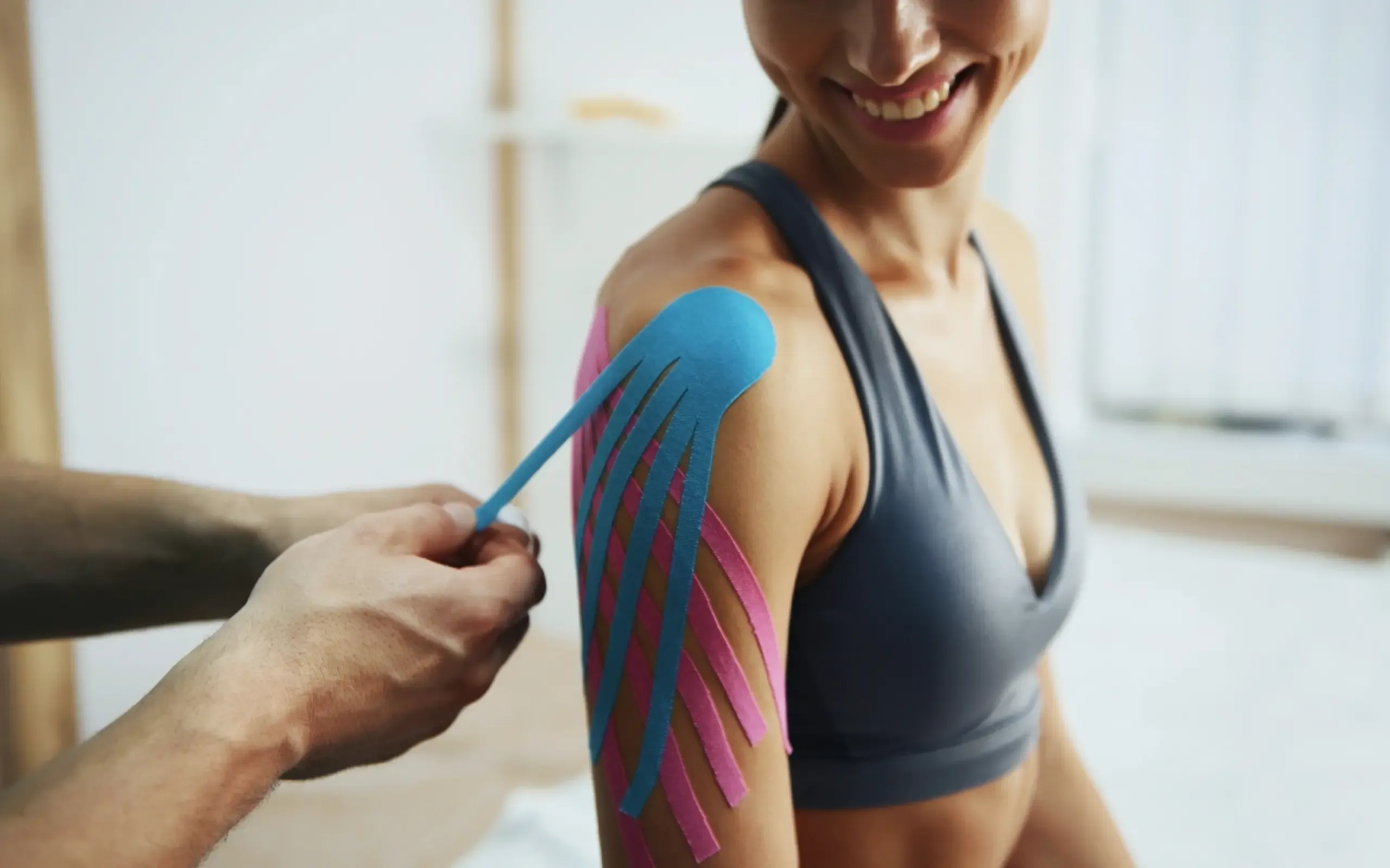 Kinesiotape wird an der Schulter angelegt