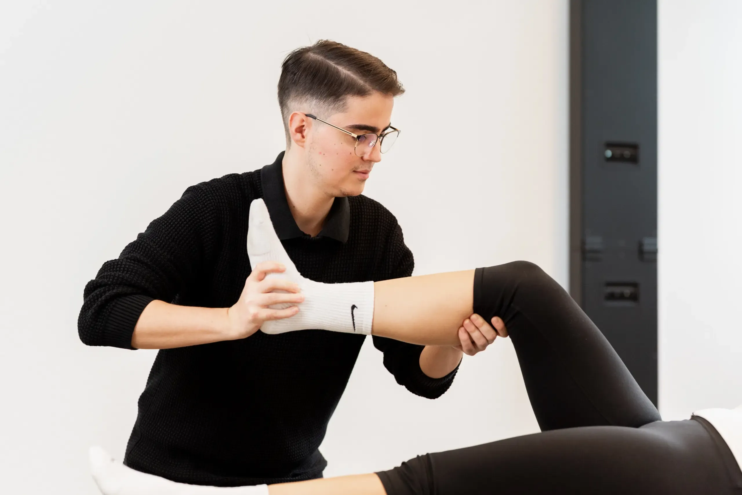 Therapeut führt das Bein einer Patientin in einem PNF-Muster